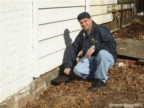 A man sitting near a wall with tool box