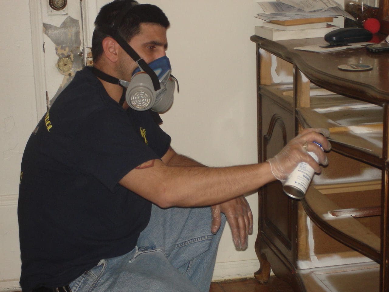A man wearing a mask spreading spray